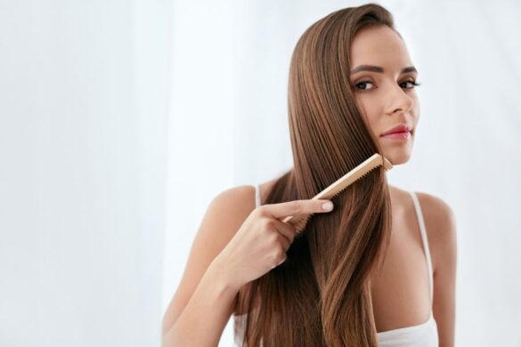 Woman brushing long healthy hair demonstrating proper hair growth care
