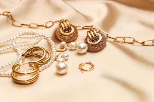 Luxurious jewelry trends collection with gold chains, pearl necklaces and textured earrings on silk fabric