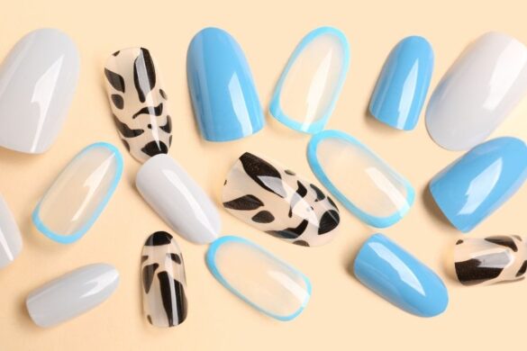 Variety of press-on nails in blue and white with decorative patterns displayed