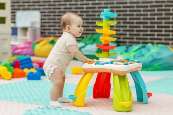 Baby playing with colorful developmental toys while demonstrating need for baby safe beauty products