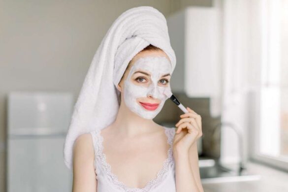 Woman applying DIY kitchen ingredient face masks with brush in modern bathroom
