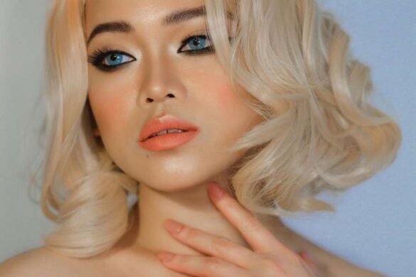 Blonde woman wearing elegant coral Valentine's Day makeup look with dramatic winged eyeliner